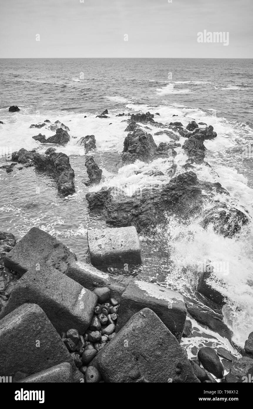 Immagine in bianco e nero di onde che si infrangono sulle rocce, Tenerife, Spagna. Foto Stock
