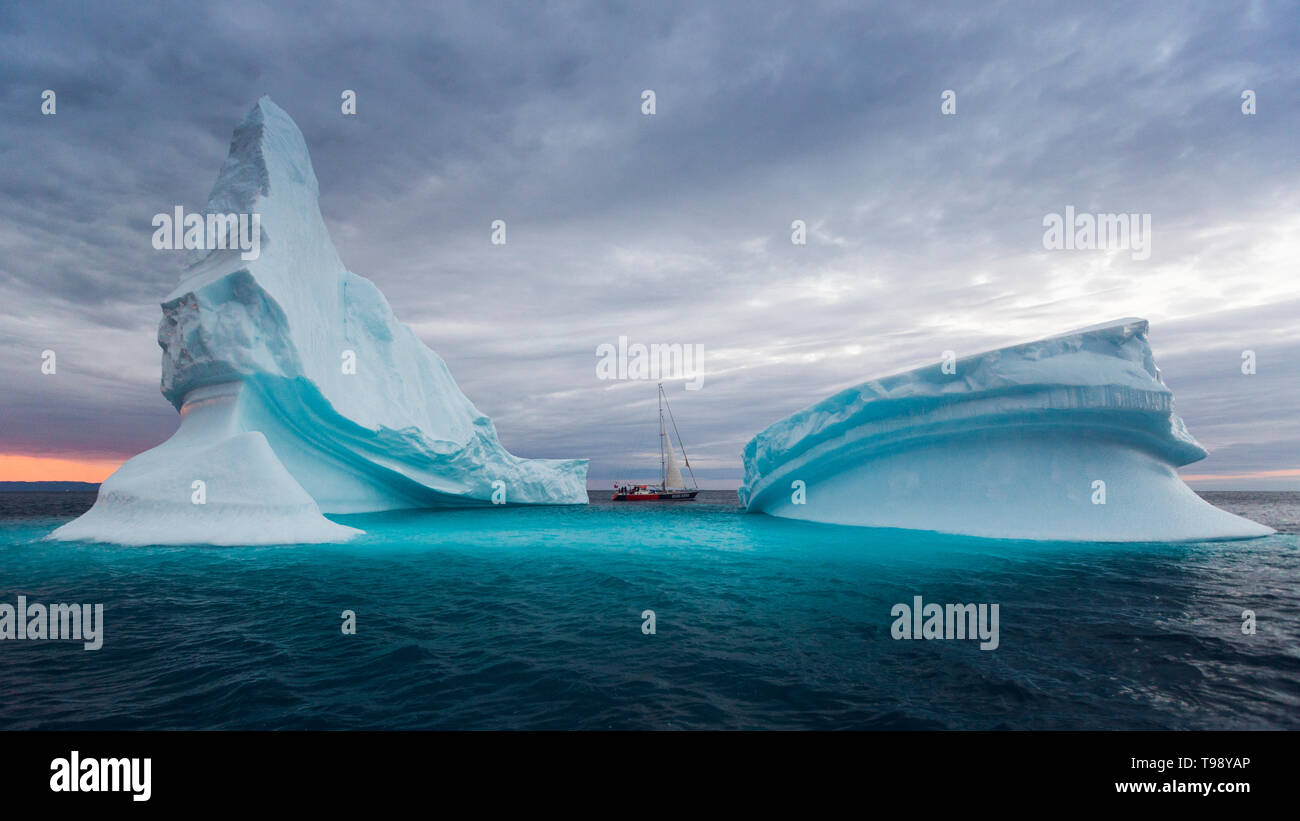 Iceberg e barca a vela nella baia di Disko su Midsummer, Groenlandia Foto Stock