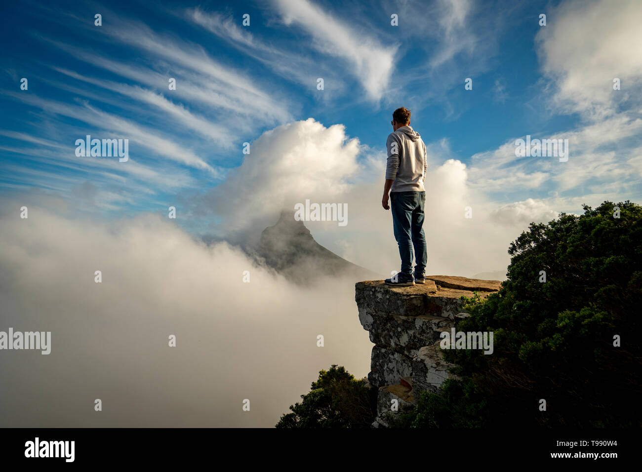 Uomo in piedi sulle rocce guardando Lions Head, Cape Town, Sud Africa Foto Stock