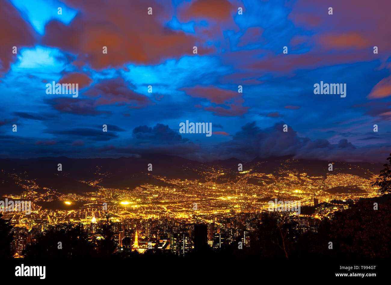 Una lunga esposizione di Medellin cityscape durante le ore di colore blu con la notte le luci della città nelle montagne delle Ande, dipartimento di Antioquia, Colombia. Foto Stock