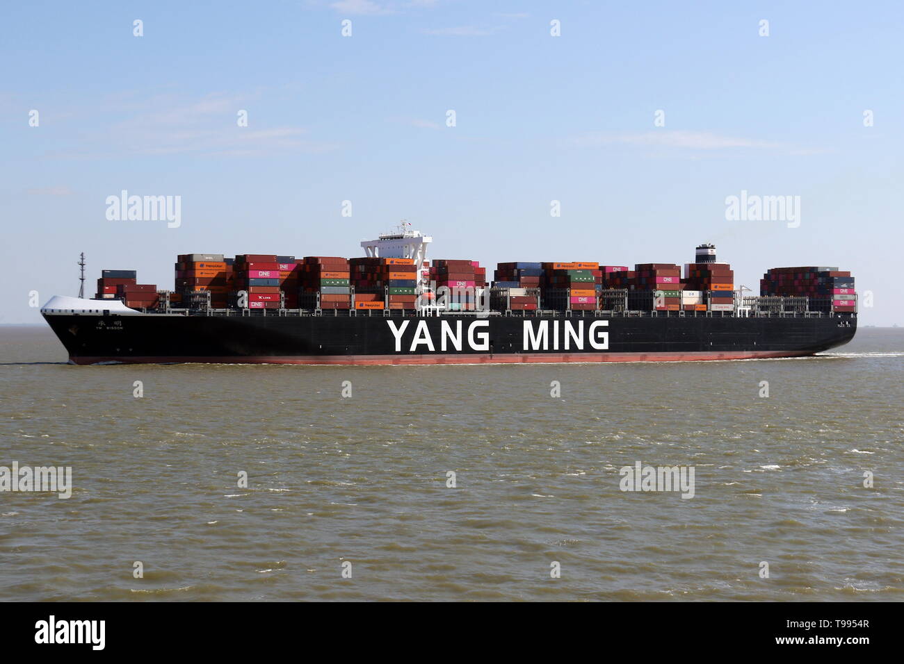La nave portacontainer YM saggezza passa il 15 aprile 2019 il porto di Cuxhaven e prosegue verso il Mare del Nord. Foto Stock