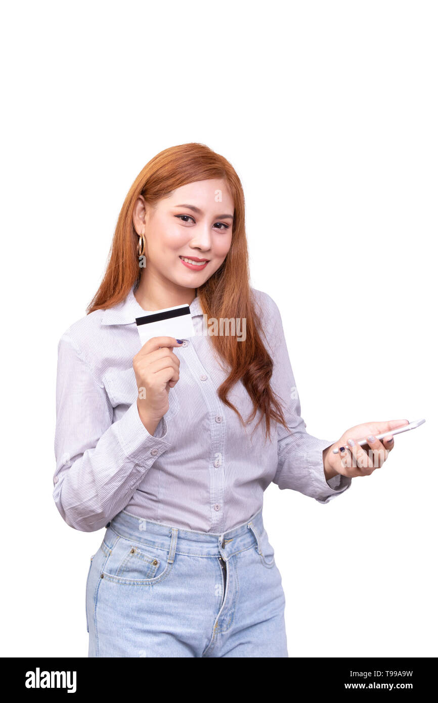 Sorridente donna asiatica in camicia casual tenendo il telefono cellulare e mostra carta di credito per gli acquisti online mentre si effettuano ordini via internet. studio shoo Foto Stock