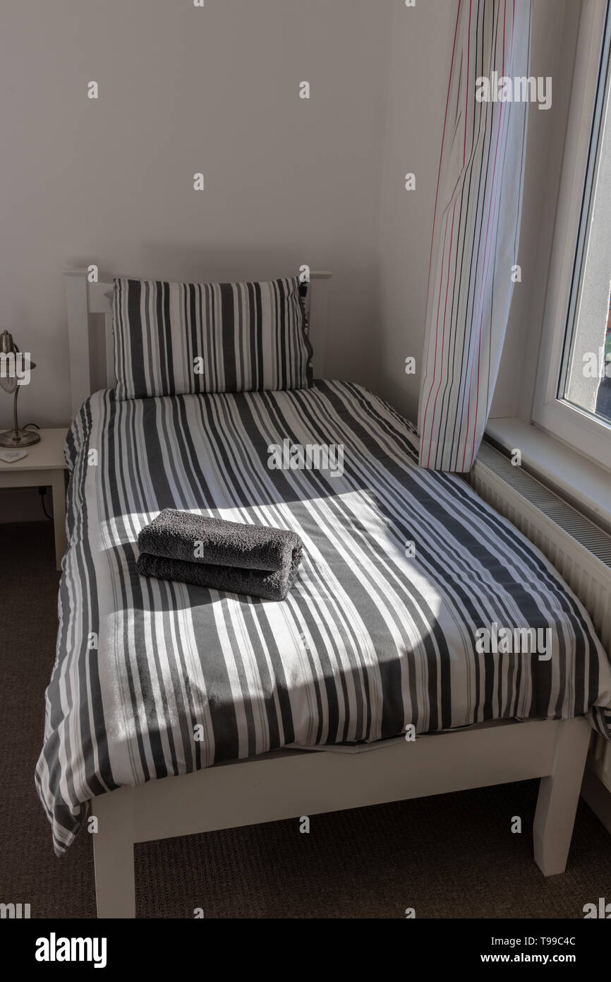 Un letto singolo in una camera da letto Foto Stock