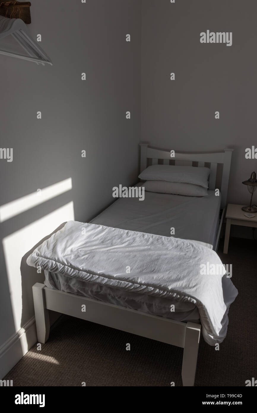 Un letto singolo in una camera da letto Foto Stock