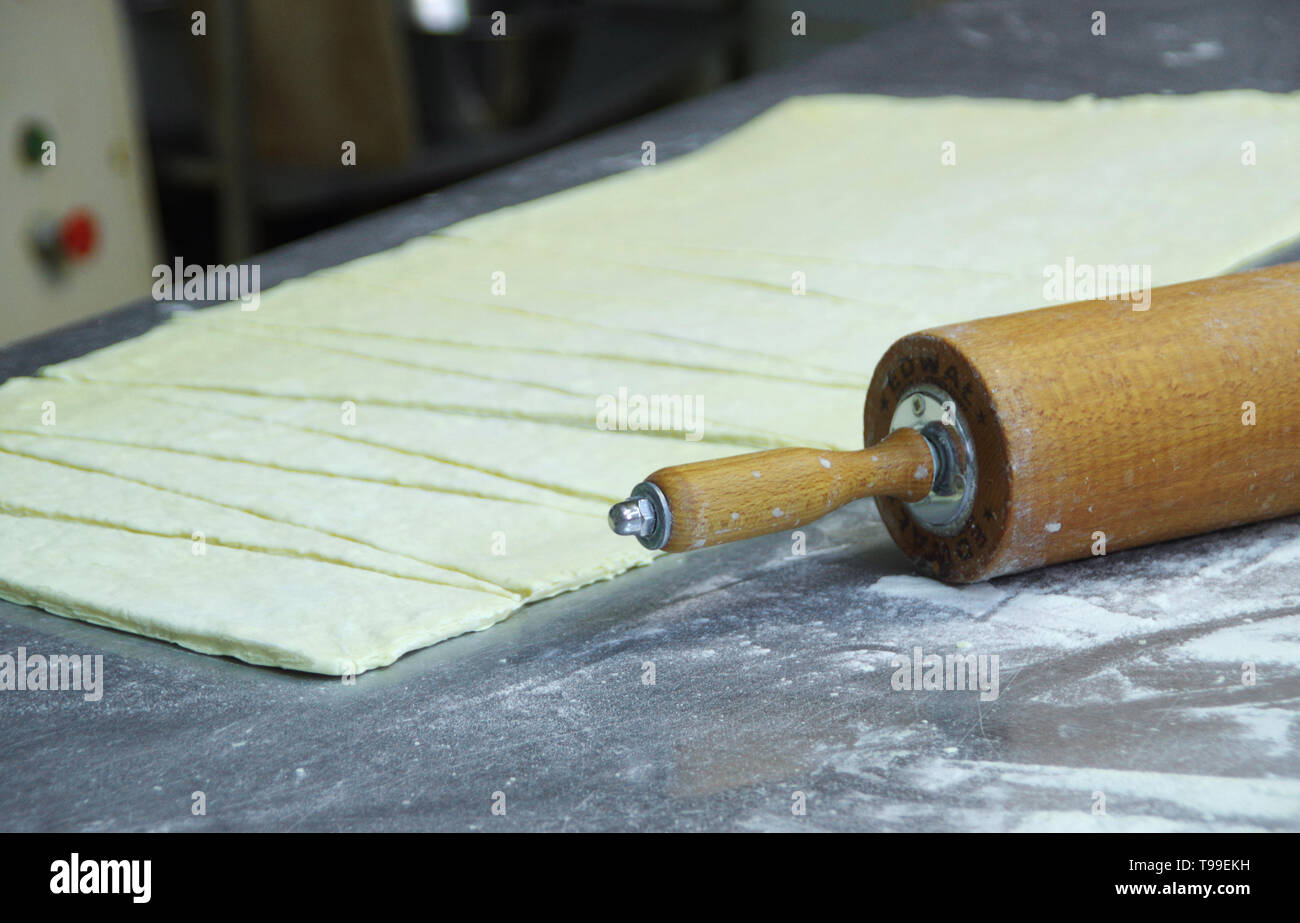 Materie torta tagliata sul tavolo. Professional preparazione di pasta al forno. Foto Stock