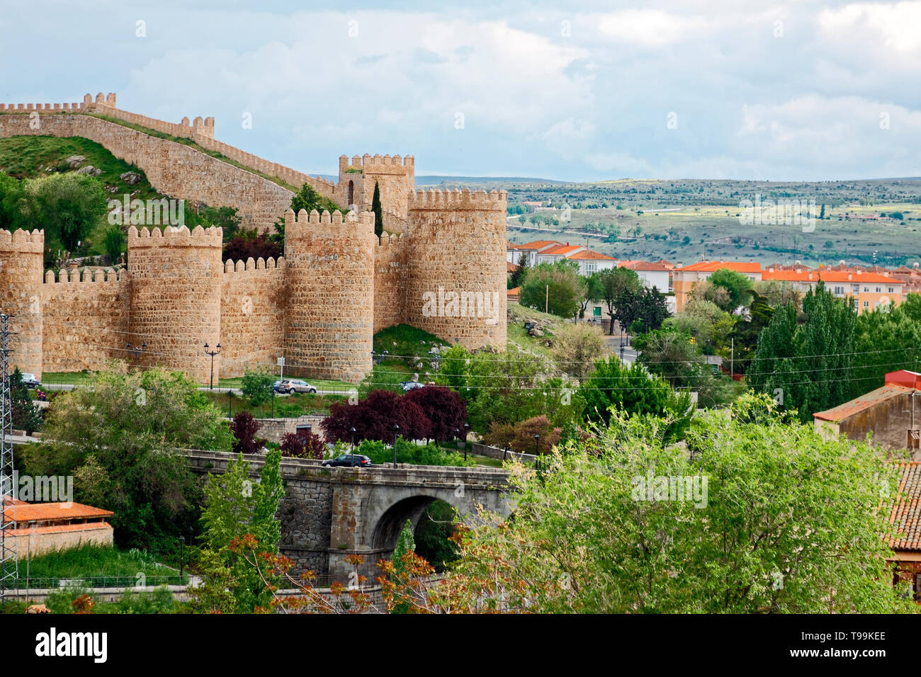 Città murata medievale;; veduta distante; torri semicircolari; case al di là, tetti rossi, terreni agricoli, paesaggio, Europa; Avila; Spagna; la molla; orizzontale Foto Stock
