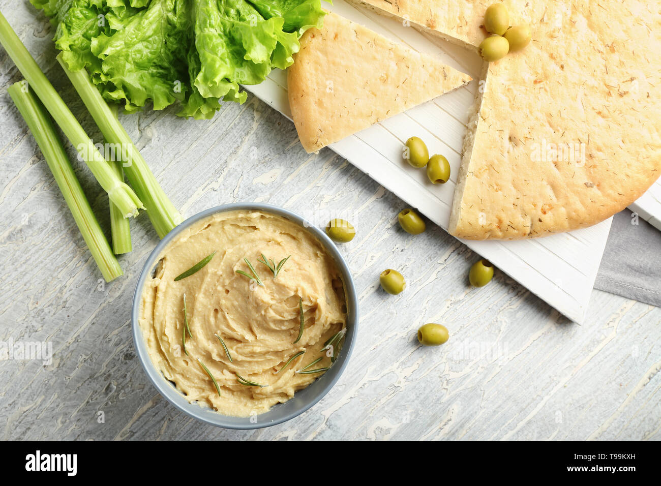 Ciotola con gustosi hummus, pane pita e olive su tavola Foto Stock