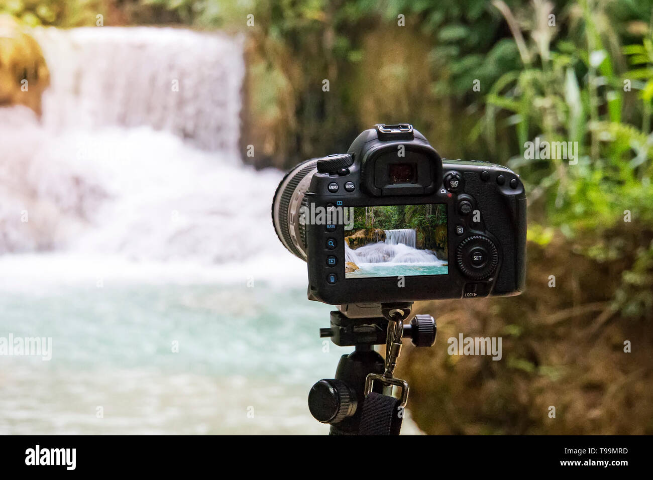 Telecamera professionale a fotografare su una lunga esposizione di belle Cascate Kuang Si in Laos. SLR Fotocamera su un treppiede girando un video dell'acqua f Foto Stock