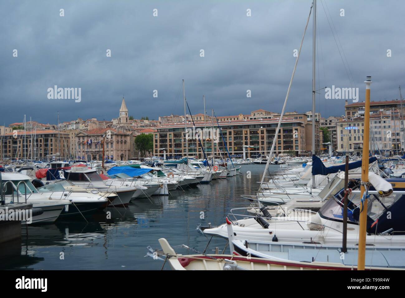 Porto di Marsiglia al crepuscolo, bagnata in golden luci, Francia. Cielo tempestoso in background. Foto Stock