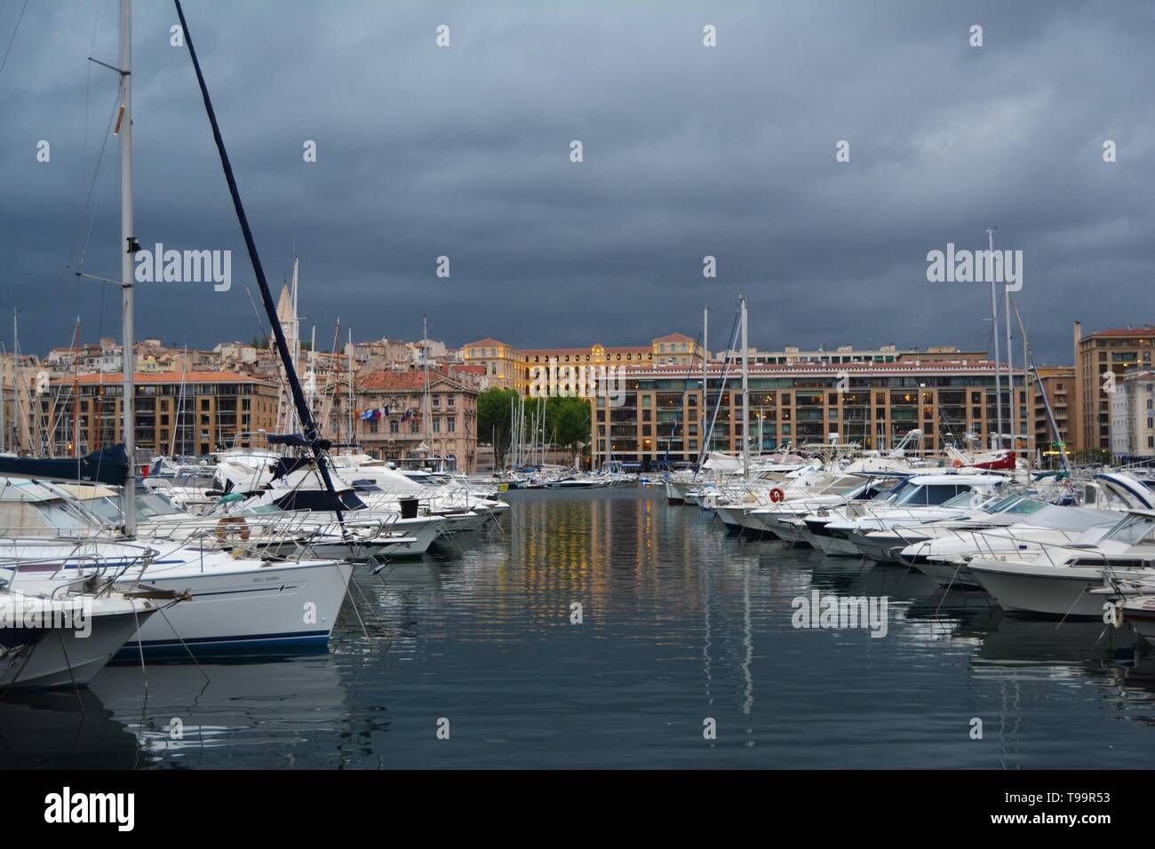 Porto di Marsiglia al crepuscolo, bagnata in golden luci, Francia. Cielo tempestoso in background. Foto Stock