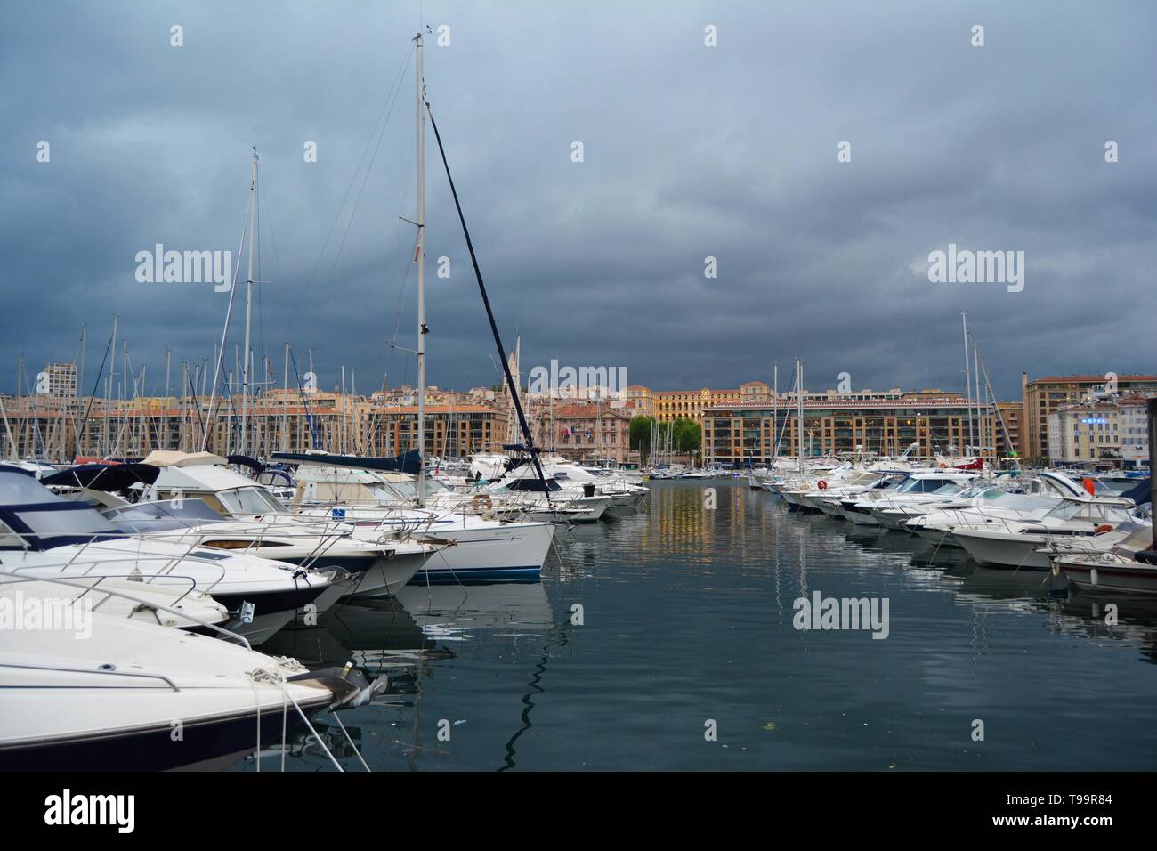 Porto di Marsiglia al crepuscolo, bagnata in golden luci, Francia. Cielo tempestoso in background. Foto Stock