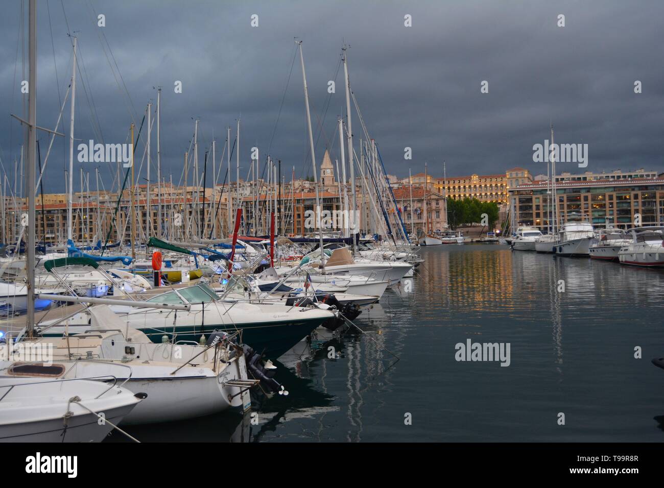 Porto di Marsiglia al crepuscolo, bagnata in golden luci, Francia. Cielo tempestoso in background. Foto Stock