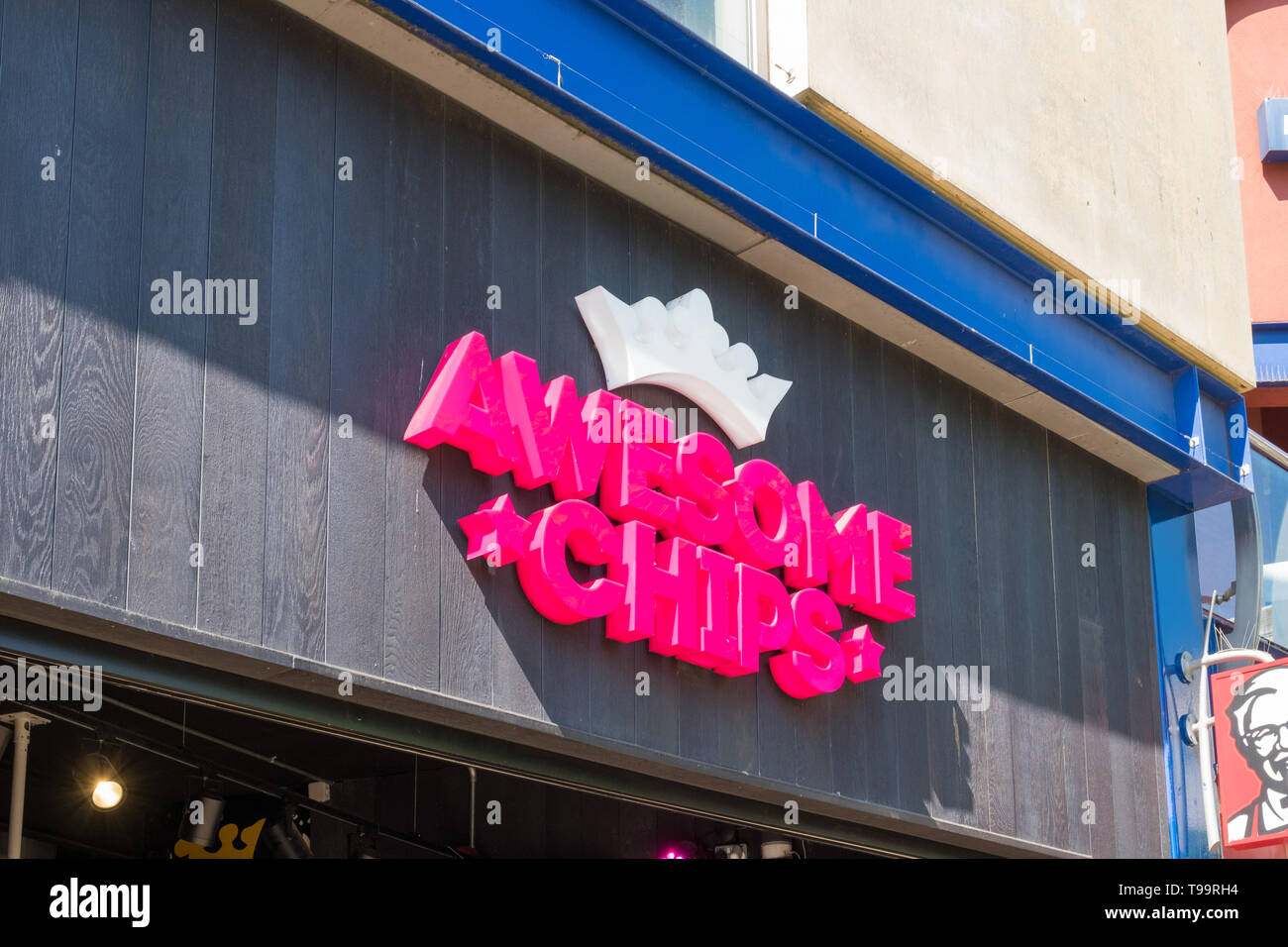 Rosa luminoso segno per il fast food outlet 'Awesome Chips" a Birmingham, Regno Unito Foto Stock