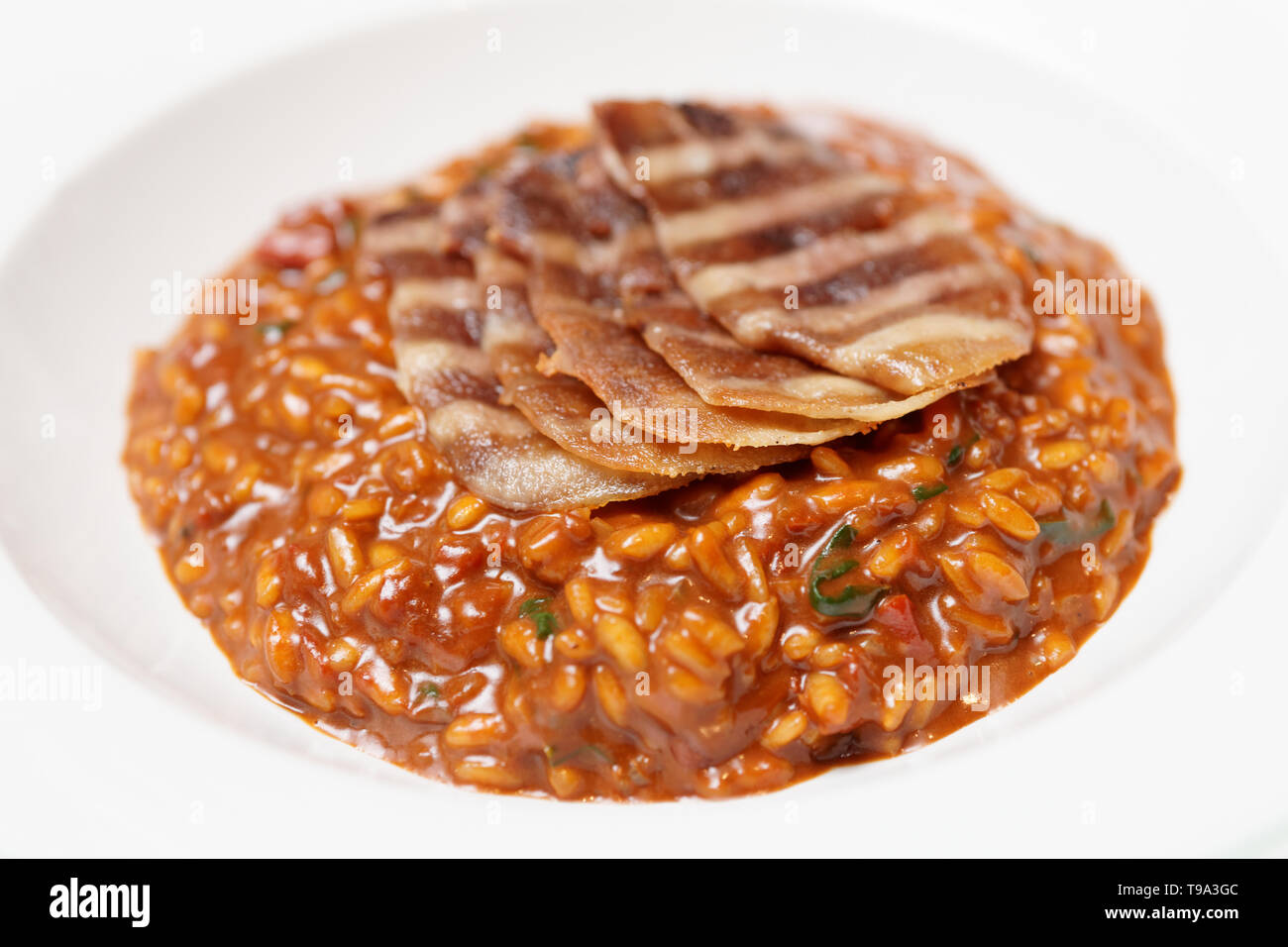 La segala risotto con grigliate di carne fette nel profondo la piastra di porcellana Foto Stock