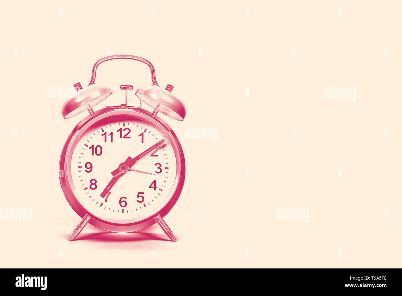 Vintage sveglia su una spiaggia di sabbia sfondo colorato con spazio per copiare in un tono duo rosso e color crema immagine design Foto Stock