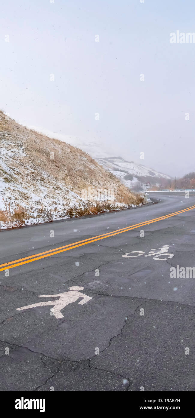 Verticale di Hill Road con pedoni e biciclette segno di corsia Foto Stock
