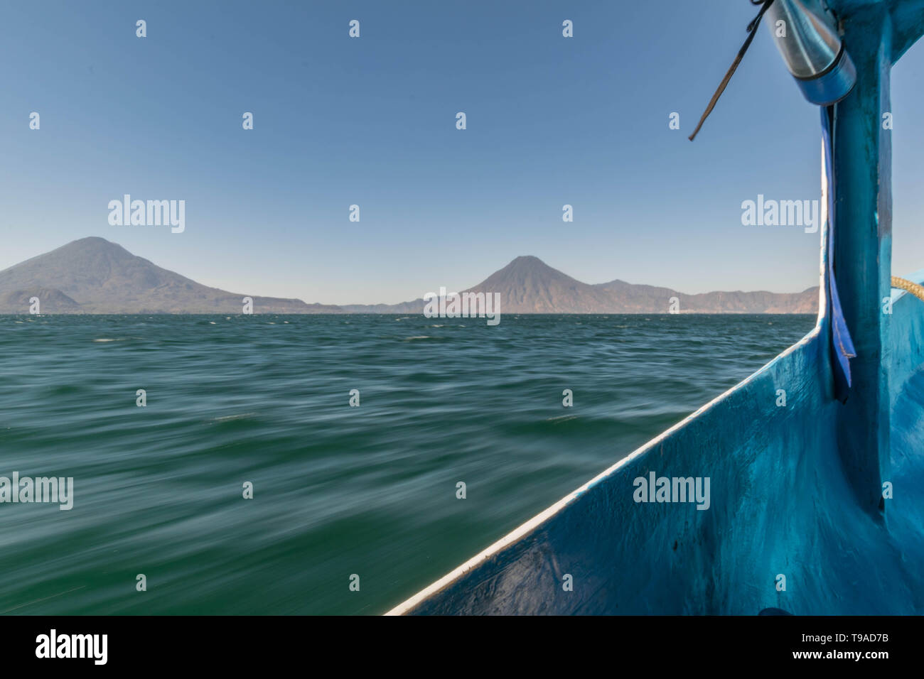 Zoomando sul lago Atitlan in una barca, con le cime del vulcano sullo sfondo, in Guatemala Foto Stock