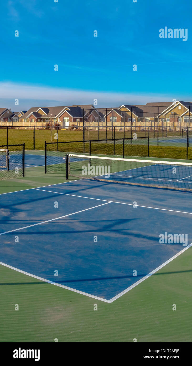 Verticale chiara campi da tennis su un ampio prato rigoglioso sotto una  vivida cielo blu con nuvole Foto stock - Alamy