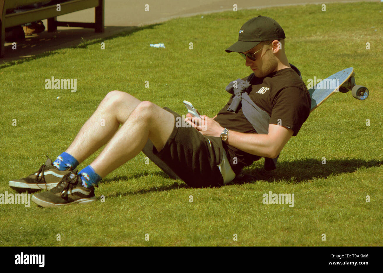 Glasgow, Scotland, Regno Unito, 17 maggio 2019, UK Meteo. Sunny scorcher di un giorno per la gente del posto e i turisti condividono l'erba con i piccioni nel centro civico della città George Square. Credito traghetto Gerard/Alamy Live News Foto Stock