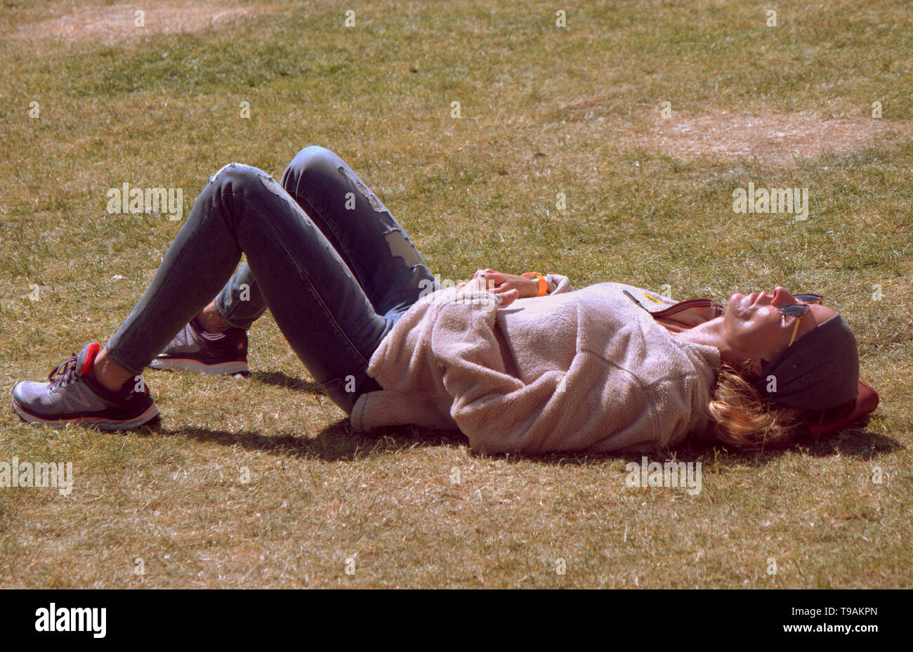 Glasgow, Scotland, Regno Unito, 17 maggio 2019, UK Meteo. Sunny scorcher di un giorno per la gente del posto e i turisti condividono l'erba con i piccioni nel centro civico della città George Square. Credito traghetto Gerard/Alamy Live News Foto Stock
