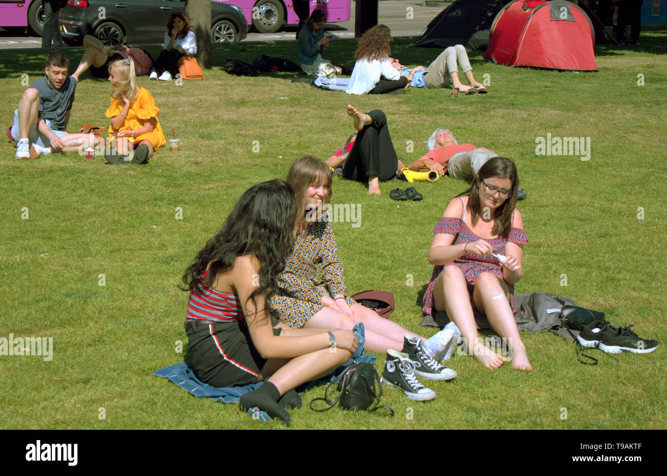 Glasgow, Scotland, Regno Unito, 17 maggio 2019, UK Meteo. Sunny scorcher di un giorno per la gente del posto e i turisti condividono l'erba con i piccioni nel centro civico della città George Square. Credito traghetto Gerard/Alamy Live News Foto Stock