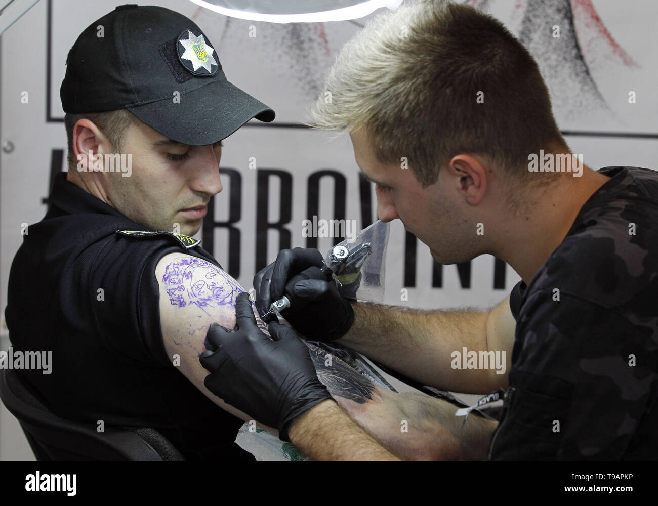 Kiev Kiev, Ucraina. Il 17 maggio 2019. Un tatuaggio artista è visto lavorare su un funzionario di polizia durante il tatuaggio di raccolta presso l annuale xv International Tattoo Convention di Kiev.il tatuaggio festival raccoglie i professionisti, gli appassionati e gli intenditori di arte del tatuaggio dal 17 al 19 maggio 2019 a Kiev. Credito: Pavlo Gonchar SOPA/images/ZUMA filo/Alamy Live News Foto Stock