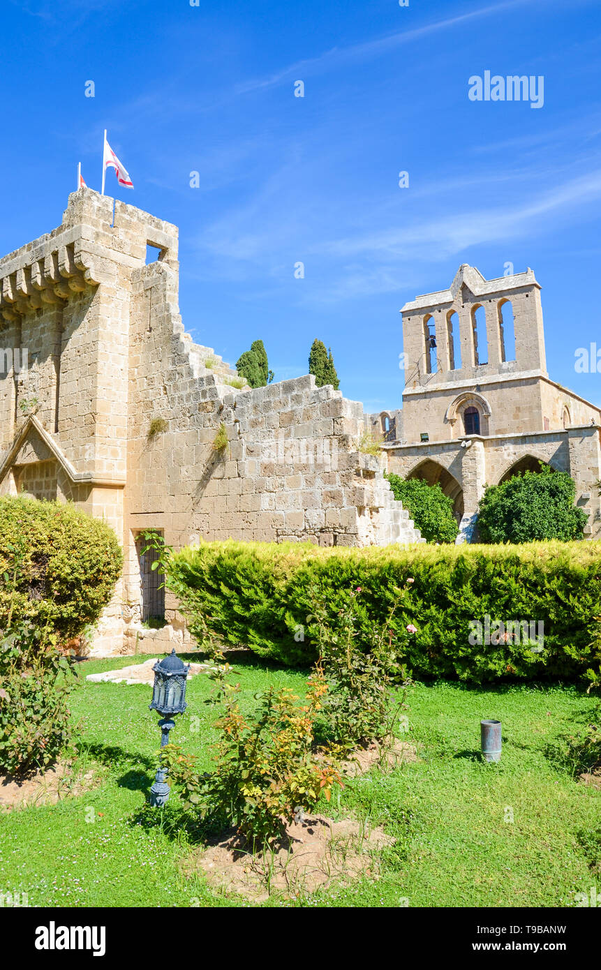 Foto verticale della medievale Abbazia Bellapais in lingua turca di Cipro nord. Acquisite con il parco adiacente e con il blu del cielo. Significativo sito storico Foto Stock