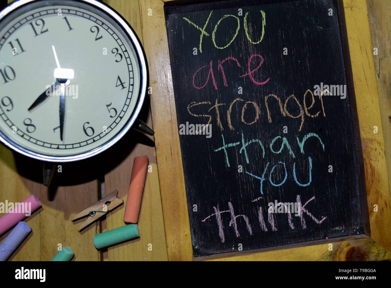 Vi sono più forti di quanto si possa pensare a una frase colorata manoscritta su lavagna e sveglia con motivazione, ispirazione e concetti di istruzione. Tabl Foto Stock