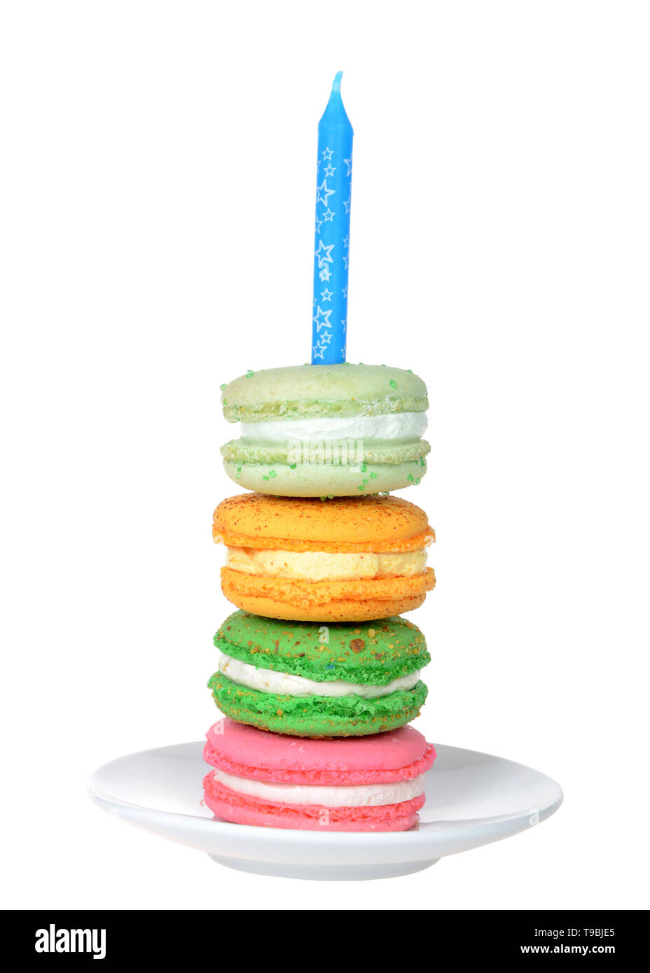 Pila di coloratissimi macaron cookie con ripieno di panna su una piastra bianca con candela blu isolato su bianco. Festa di compleanno del tema. Foto Stock