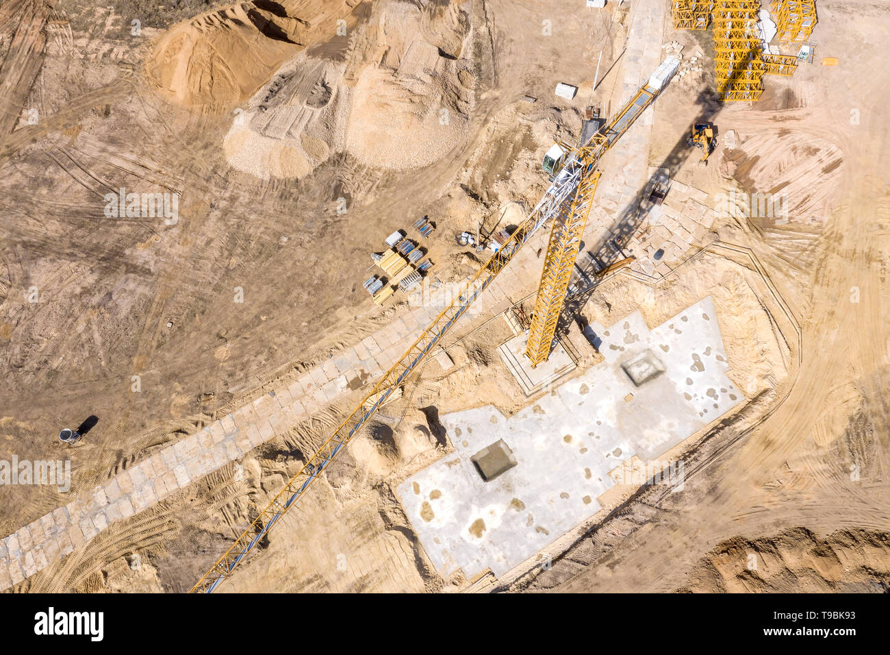 Giallo gru a torre permanente al sito in costruzione. La preparazione del terreno per i futuri lavori edili. antenna vista superiore Foto Stock