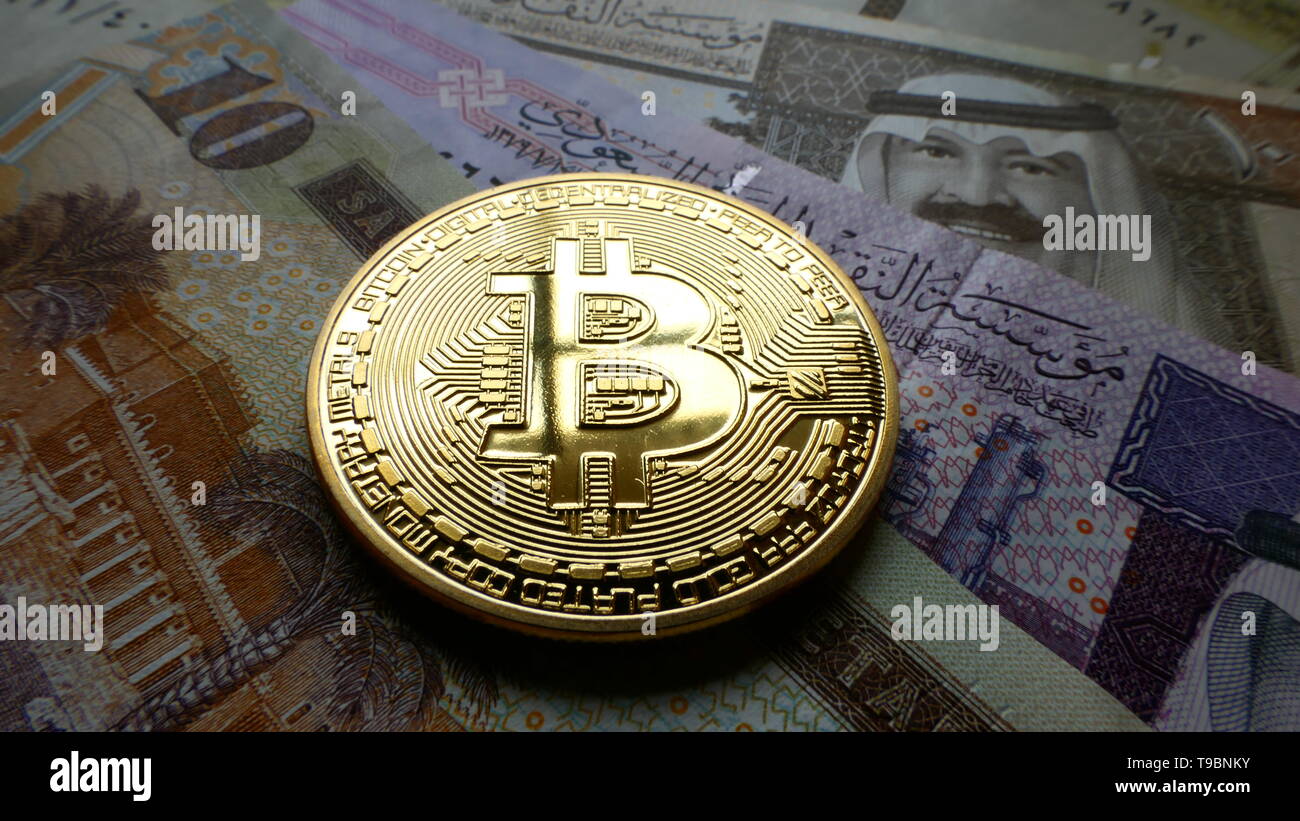 Bitcoin, una moneta virtuale in moneta fisica forma, visualizzato su Saudi Arabian Riyal banconote Foto Stock