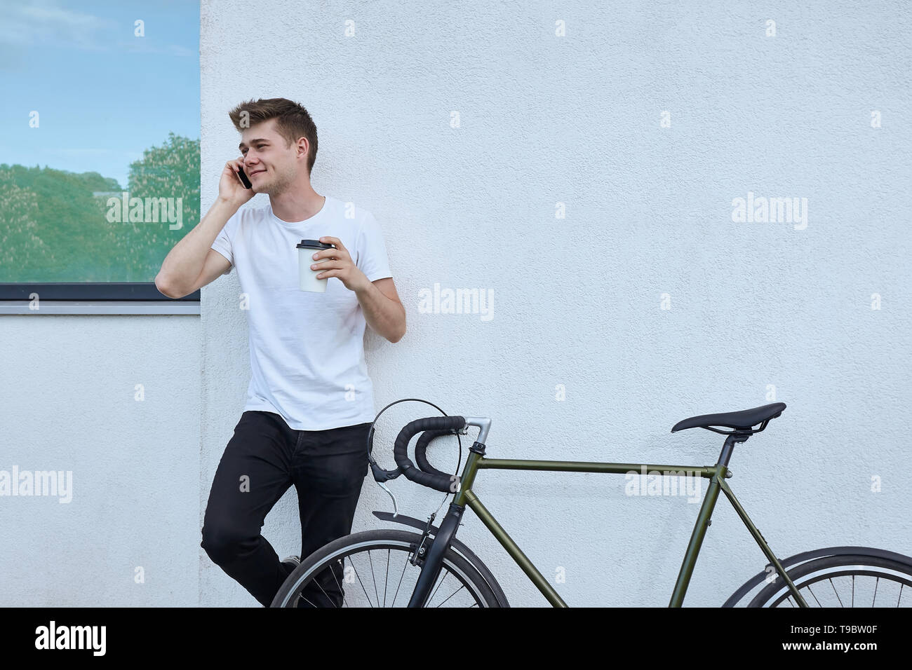 Bello hipster uomo in posa con la bicicletta in città. Foto Stock