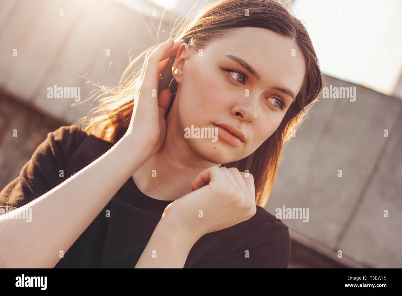 Close up ritratto di giovane bella lunga vento capelli ragazza modello di moda sulla strada di città Foto Stock