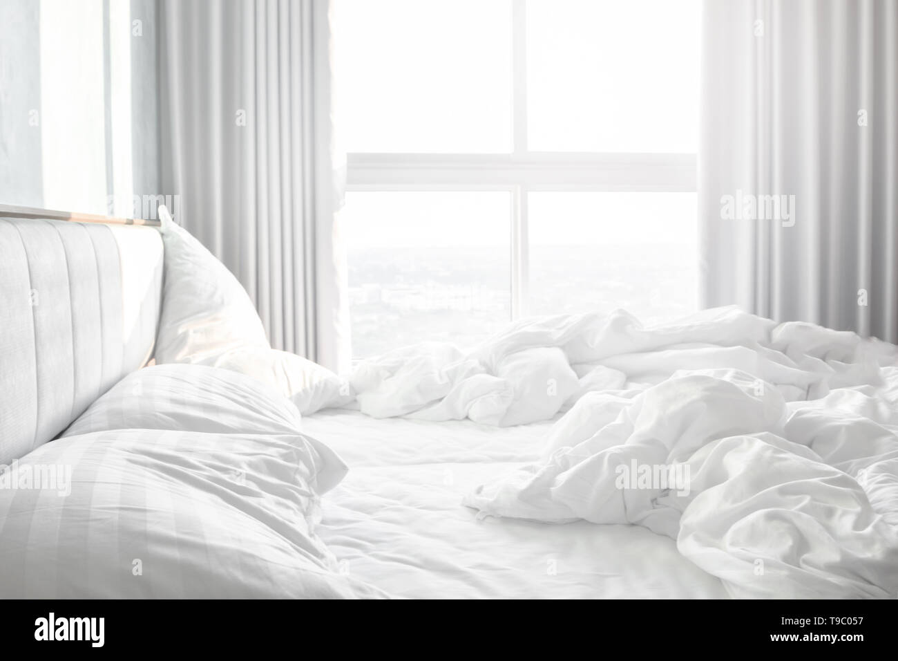 Confortevole camera da letto,confuso lenzuola e piumone con grinza disordinati in camera da letto Foto Stock
