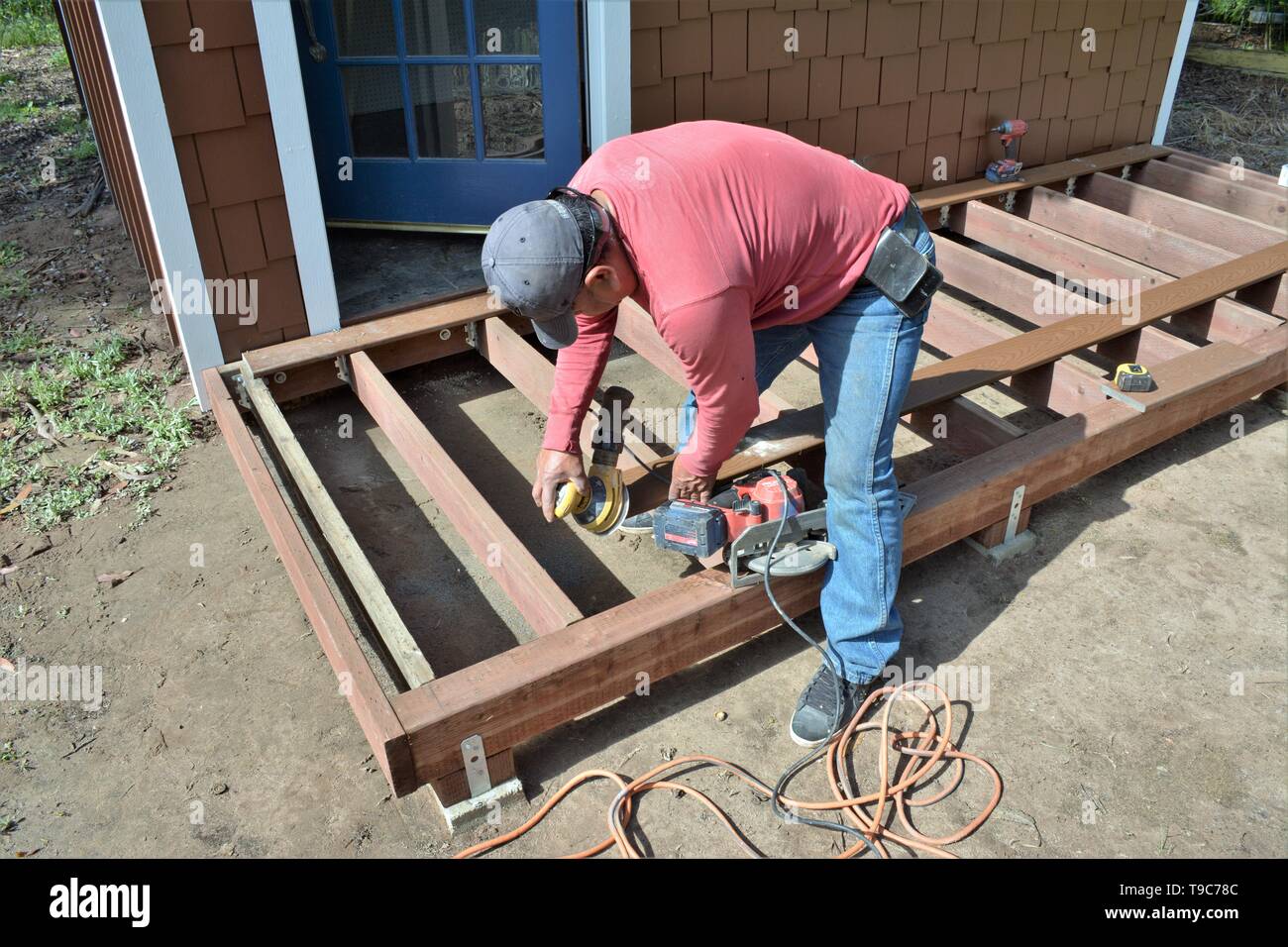 Senior falegname messicano lavorando su legno decking con strumenti e Trex fabbricato boschi in California America Foto Stock