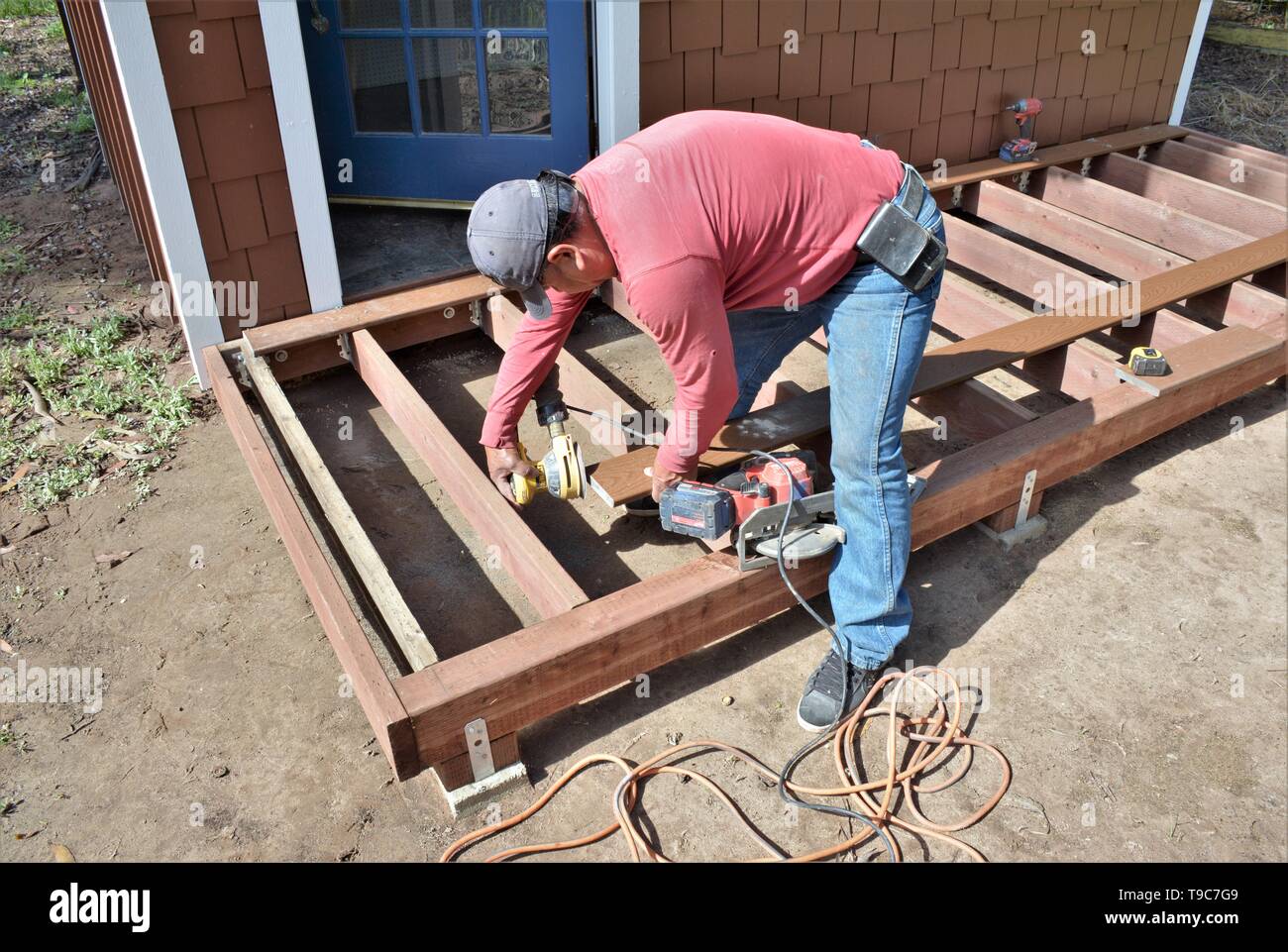 Senior falegname messicano lavorando su legno decking con strumenti e Trex fabbricato boschi in California America Foto Stock