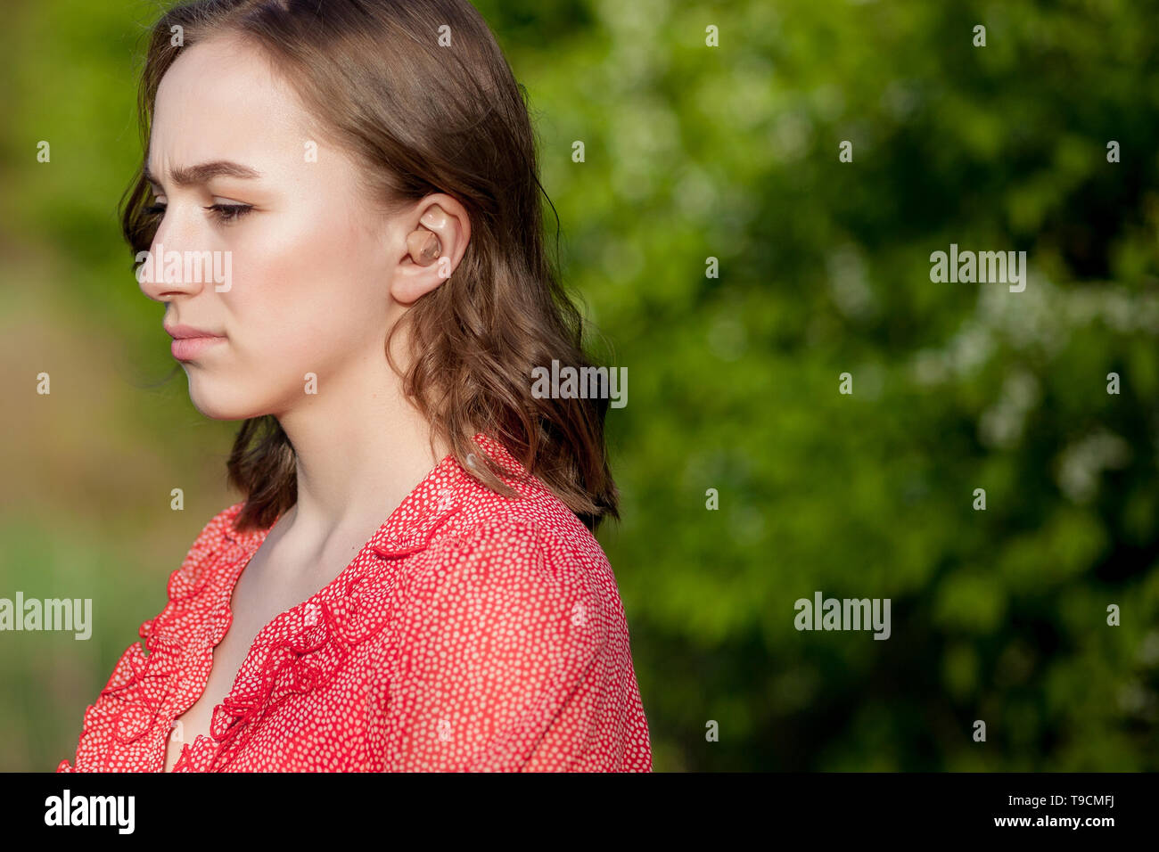 Close-up di mani femminili di mettere protesi in orecchio. Digitali moderne nell'orecchio udito aiuti per la sordità e il disco di pazienti udenti. Foto Stock