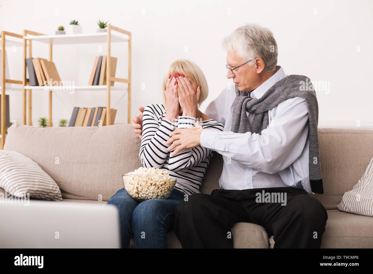 Spaventata Senior donna guardando film horror con mio marito Foto Stock