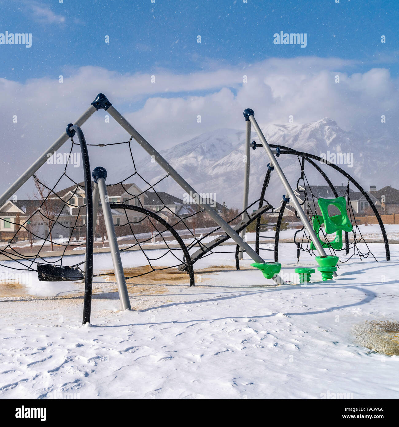Chiara Piazza telai di arrampicata su un parco giochi polmonato con neve su una soleggiata giornata invernale Foto Stock