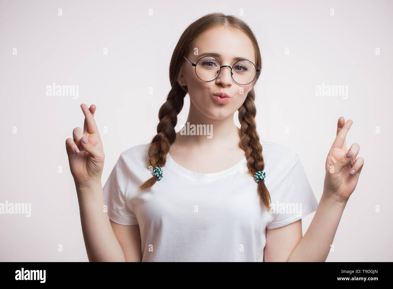 Giovani Caucasici Divertenti Ragazza Con Trecce E Occhiali Incrocia Le Dita Per La Buona Fortuna Guardando La Fotocamera Su Sfondo Bianco Foto Stock Alamy