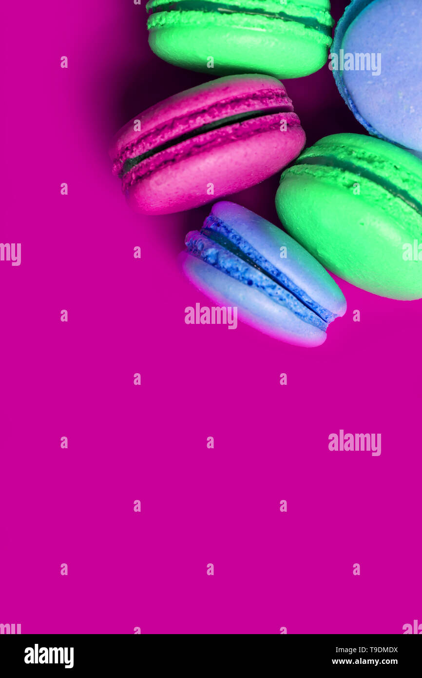 Primo piano della coloratissima amaretti dolce su uno sfondo viola con copia spazio. Foto Stock