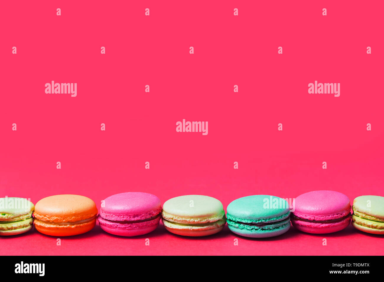 Rosa di sfondo per il testo con colorate blu francese, arancione, verde, beige amaretti, copia dello spazio. Foto Stock