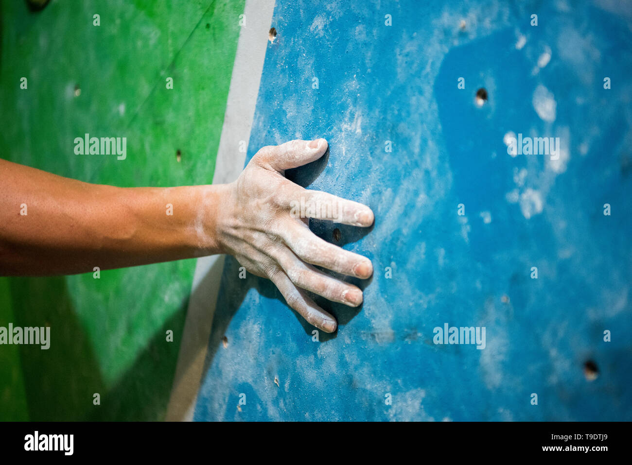 Un uomo detiene il muro di roccia da scalare pietre nel punto di inizio. Foto Stock