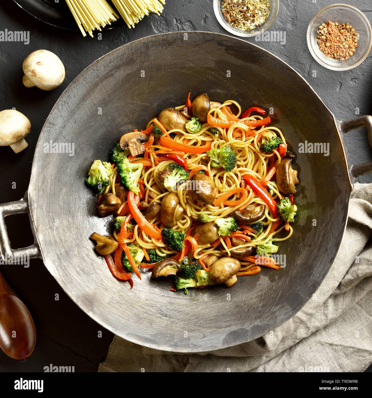 Friggere gli spaghetti con le verdure nel wok padella in pietra nera dello  sfondo. Vista superiore, laici piatta Foto stock - Alamy