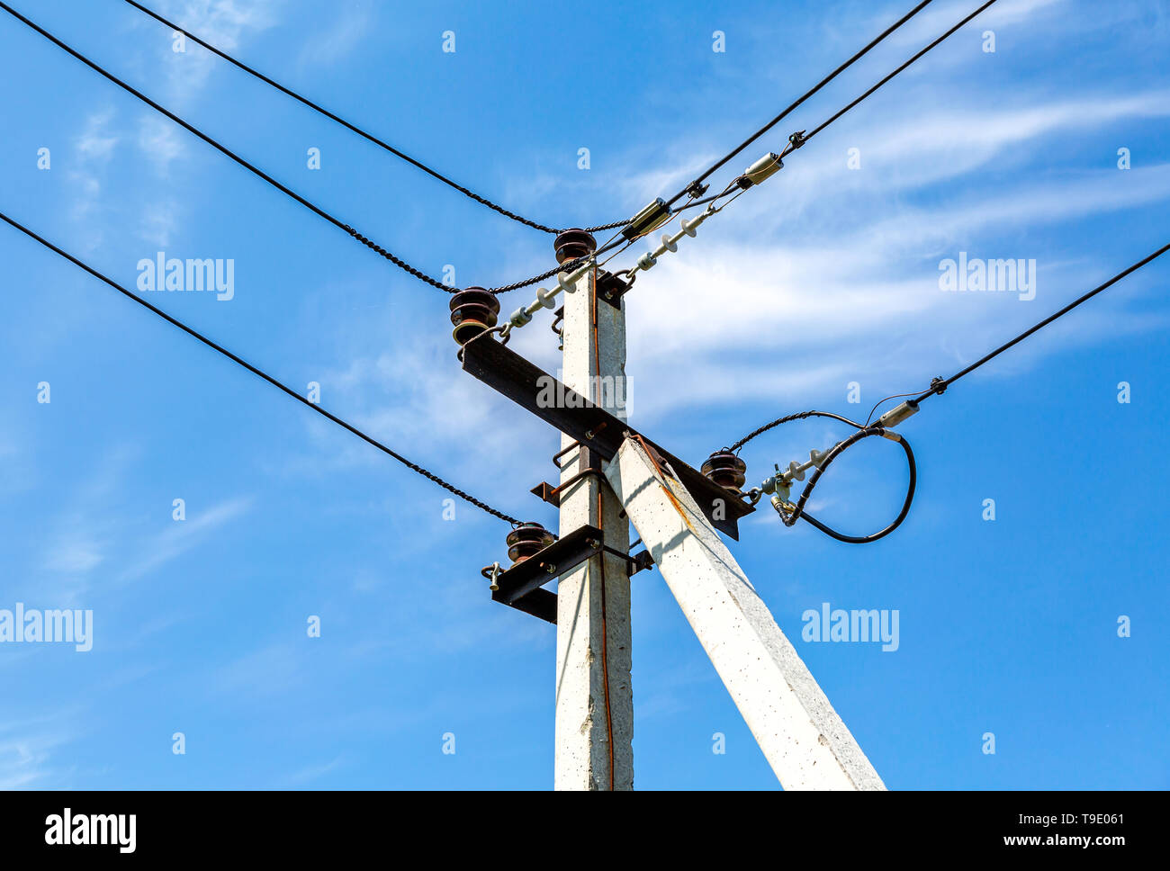 Di energia elettrica ad alta tensione pilone con i fili contro il cielo blu Foto Stock
