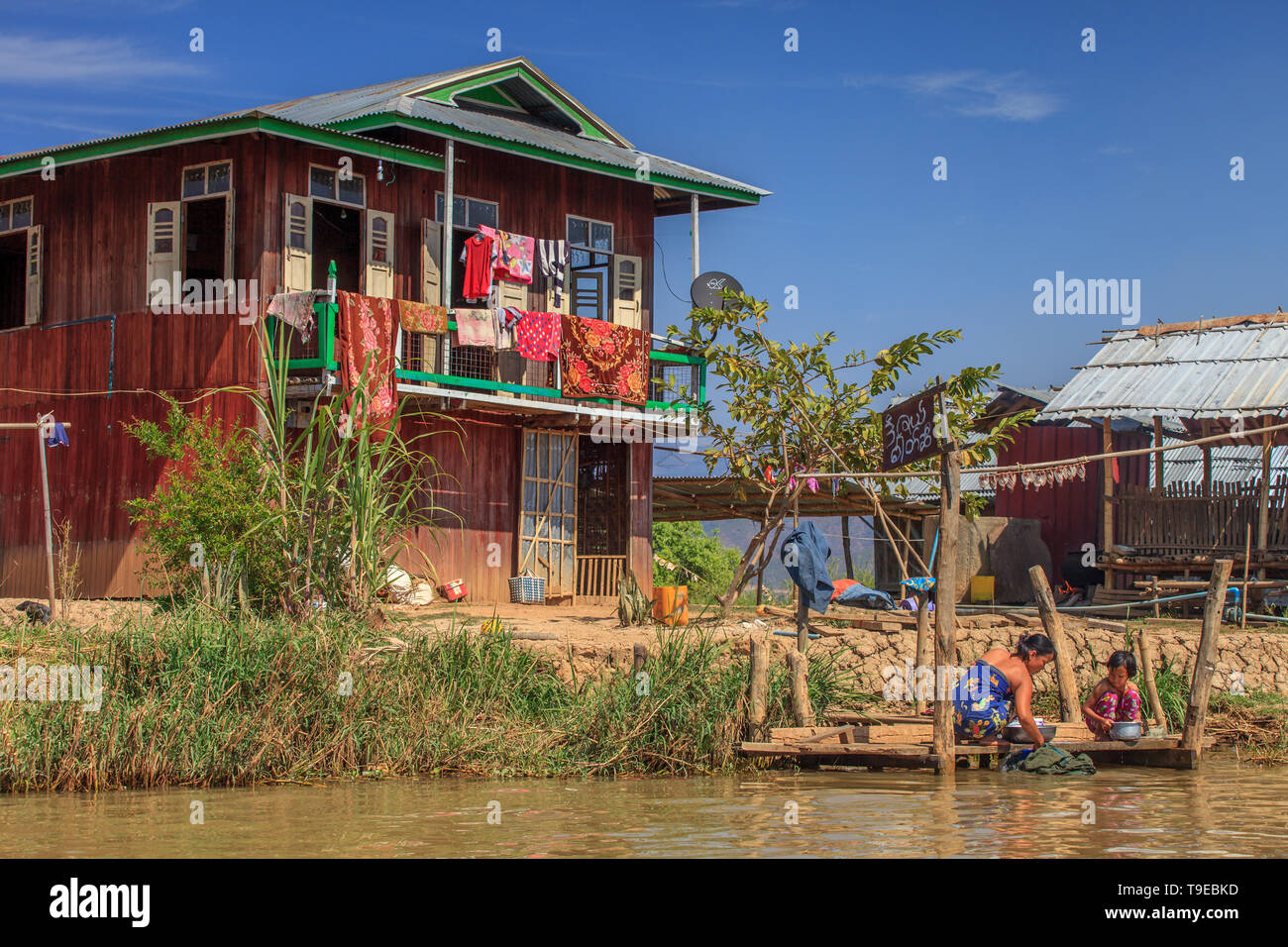 Madre e figlia il bucato davanti alla loro casa, Lago Inle Myanmar Foto Stock