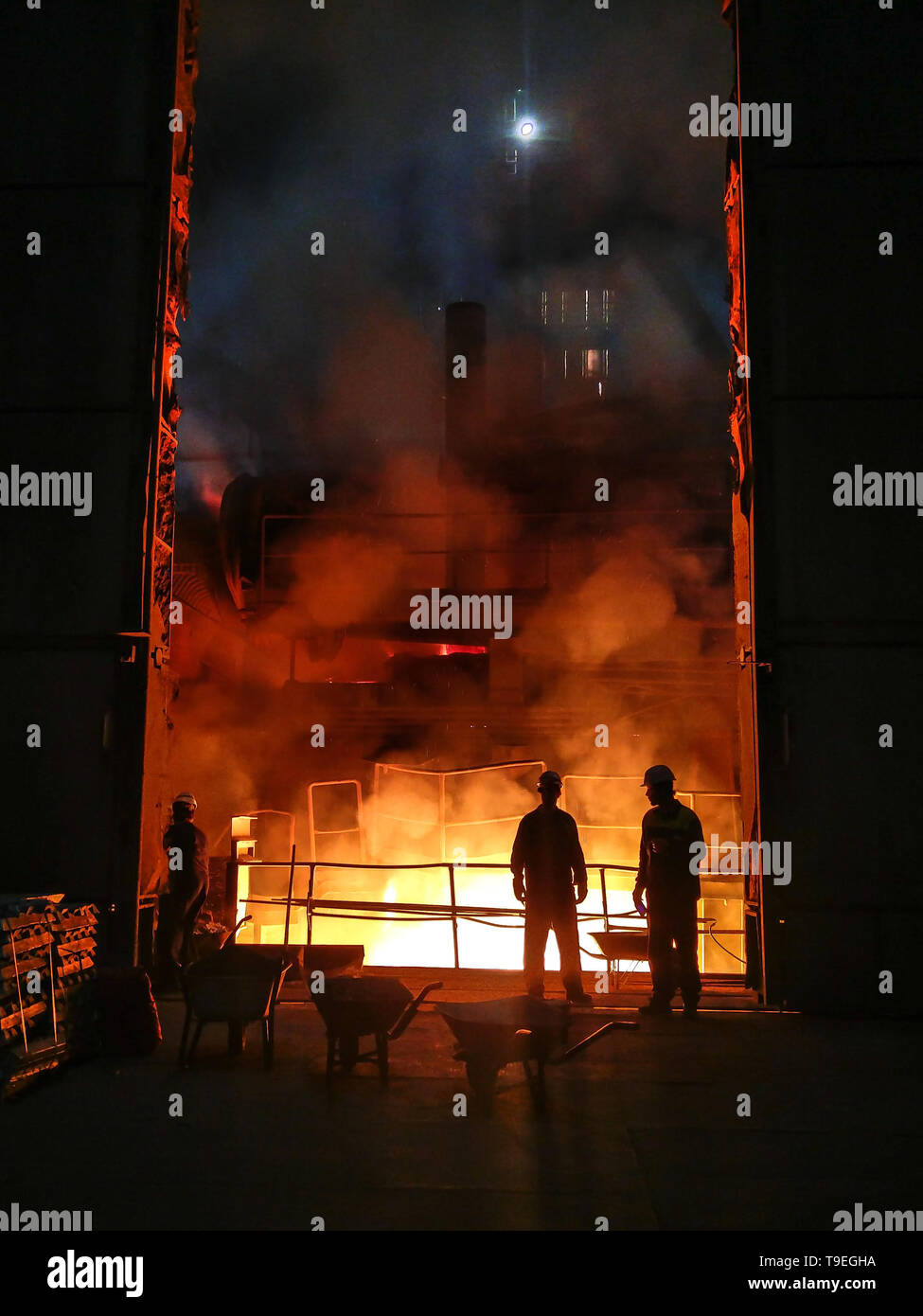 Fusione del metallo nella grande fonderia. Produzione di ferro e acciaio in un impianto metallurgico. Lavoratore di acciaio. Processo di metallurgia. Foto Stock