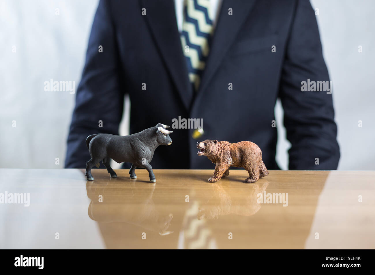 Il mercato azionario, il commercio di valori mobiliari e il capitalismo concetto con un toro e orso concetti. Commerciante di business man in tuta in background. Foto Stock