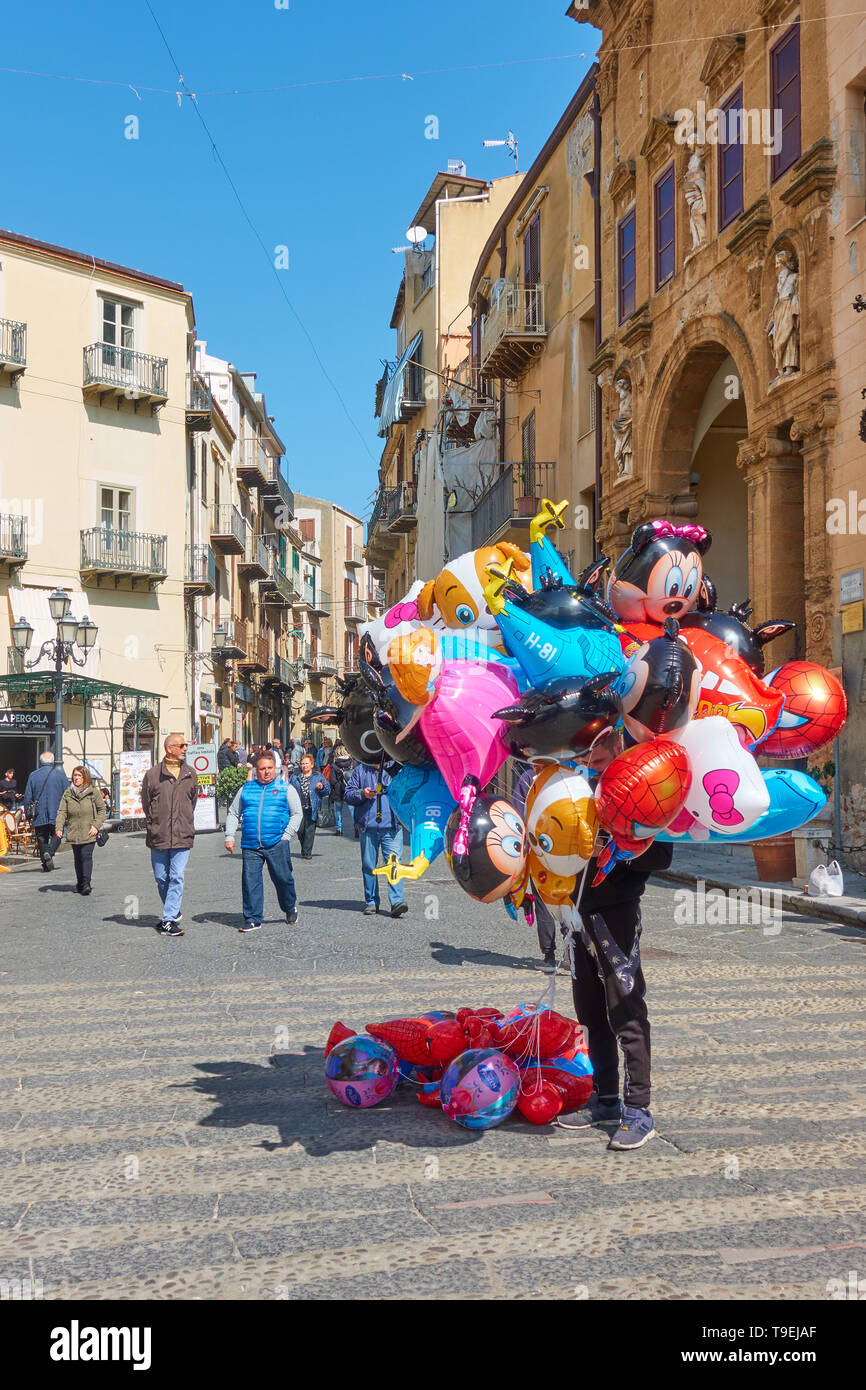 Cefalù, Italia - 19 Marzo 2019: Aria palloncini venditore in strada nel centro storico di Cefalù Foto Stock
