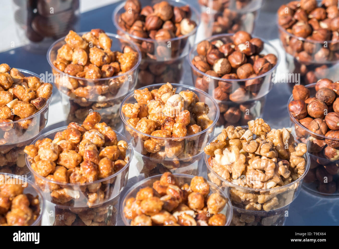 Una varietà di dadi in ciotole di plastica nel mercato all'aperto, cibo sano Foto Stock